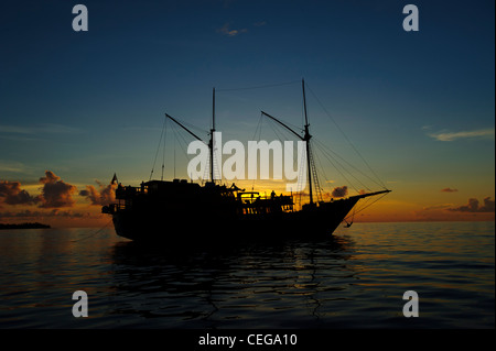 Die Damai Liveaboard vertäut in Lucipara Atoll Banada Meer, Indonesien. Sonnenuntergang erschossen. Eine schöne traditionelle Phinisi Schiff. Stockfoto