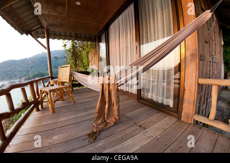 Hängematte und Stuhl auf der Terrasse des Bungalows auf tropischen Resort, Thailand Stockfoto