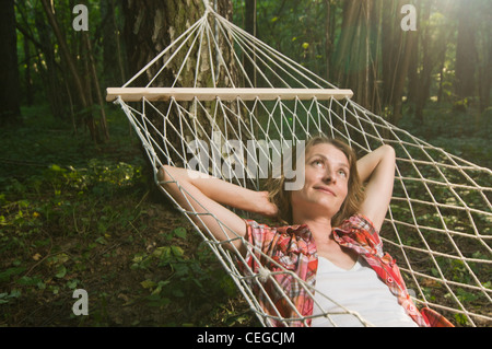 Schöne Frau in Hängematte draußen im Wald entspannen Stockfoto
