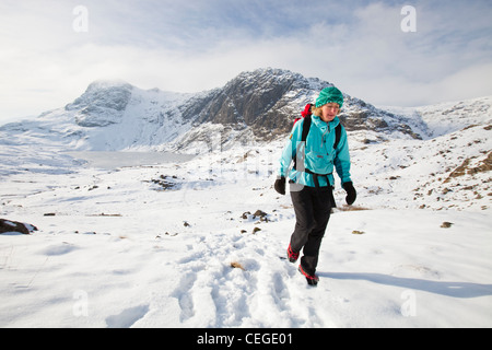 Frau Hill Wanderer über einen gefrorenen scheut Tarn in die saisonabhängige, Lake District, Großbritannien Stockfoto