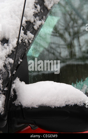 Nahaufnahme der Seitenspiegel und Reflexion der Äste am Fenster der schwarze Wagen unter weißen Schnee Stockfoto