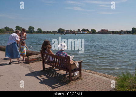 Menschen sitzen neben dem Hafen am Bosham genießen Stockfoto