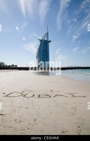 Burj Al Arab (Arabisch: برج العرب, Turm der Araber mit Dubai in den Sand geschrieben Stockfoto