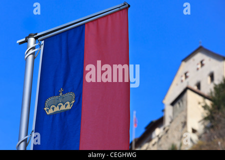 Die offizielle Flagge des Fürstentums Liechtenstein in den Vordergrund und Schloss Vaduz im Hintergrund, Liechtenstein Stockfoto