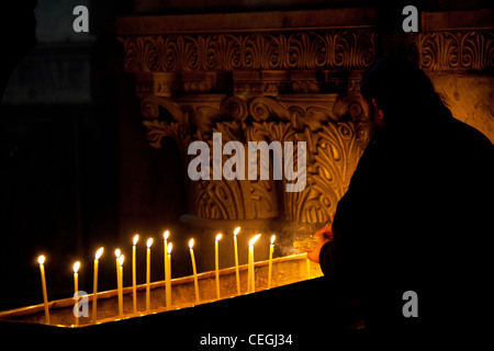 Ein Priester tendenziell Kerzen in der Kirche des Heiligen Grabes in Jerusalem Stockfoto