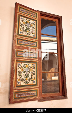 Eine Reflexion in einem Fenster des Innenhofes von Ben Youssef Madrasa, Marrakesch, Marokko Stockfoto