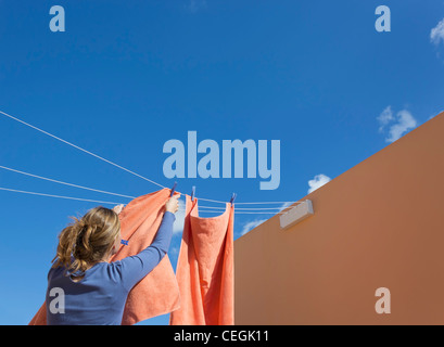 Junge Frau pegging, waschen, trocknen lassen. Stockfoto