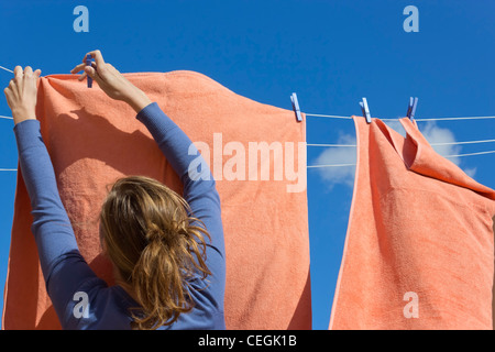 Junge Frau pegging, waschen, trocknen lassen. Stockfoto