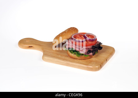 Roastbeef mit Salat und Tomate Salat sandwich in "Sesam" Brötchen auf Holz Deli Brett auf weißen Hintergrund isoliert Stockfoto