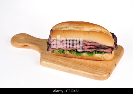 Gebratenes Rindfleisch mit Salat und Tomaten-Salat-Sandwich in Brot u-Boot Rollen auf Holz Deli Brett auf weißen Hintergrund isoliert Stockfoto