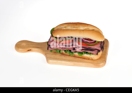 Gebratenes Rindfleisch mit Salat und Tomaten-Salat-Sandwich in Brot u-Boot Rollen auf Holz Deli Brett auf weißen Hintergrund isoliert Stockfoto