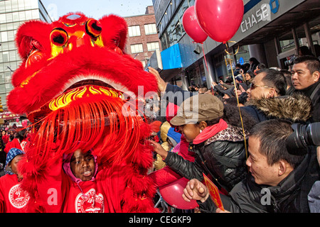 Zuschauer berühren einen leuchtenden roten Drachen als Glücksbringer bei der 2012 chinesischen Lunar New Year Parade in New Yorks Chinatown Stockfoto