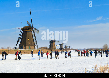 In der Regel niederländischen Szene Menschen Eislaufen auf Natureis mit den Windmühlen von Kinderdijk als Kulisse zu zeigen. Stockfoto