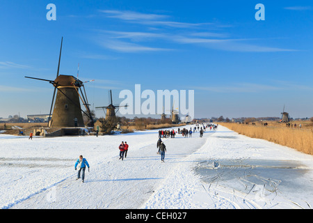 In der Regel niederländischen Szene Menschen Eislaufen auf Natureis mit den Windmühlen von Kinderdijk als Kulisse zu zeigen. Stockfoto