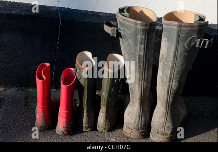 Drei Paar Gummistiefel in verschiedenen Größen in Folge Stockfoto