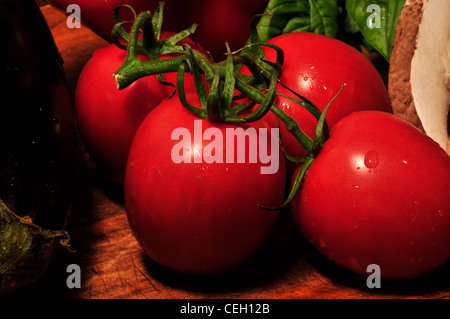 Portabella Pilze, Reben gereifte Tomaten, frischem Basilikum und Auberginen auf ein Schneidebrett. Stockfoto