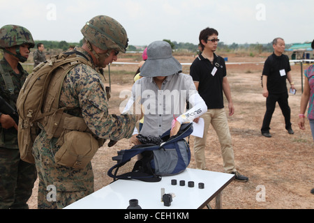 U.S. Marine Corps CPL. John Cano, rechts, von der 31. Marine Expeditionary Unit durchsucht während der simulierten nicht-kämpferischen Evakuierungsoperationen eine Tasche eines Evakuierten Rayong, Königreich Thailand, 12. Februar 2012. Das Royal Thai Marine Corps, die US-Marine, die Japan Self Defense Forces, die malaysischen und singapurischen Streitkräfte nahmen alle an der NEO-Ausbildung während der Übung Cobra Gold 2012 Teil. Die Übung verbessert die Fähigkeit, gemeinsame Operationen zu planen und durchzuführen, Beziehungen zwischen den Partnerländern aufzubauen und die Interoperabilität in der Region Asien-Pazifik zu verbessern. Stockfoto