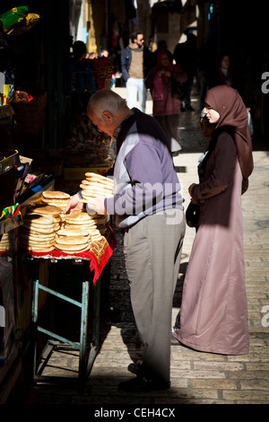 Eine Frau einkaufen bei einem Brot Stand in Jerusalem Stockfoto