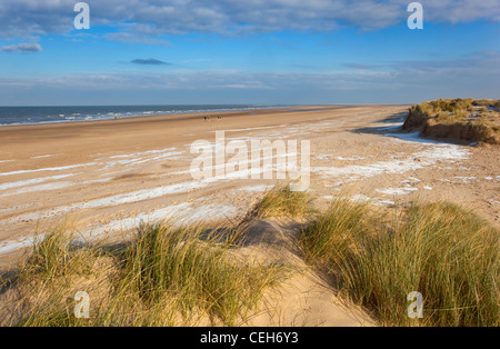 Schnee bedeckt die Dünen und Strand von Holkham Bay an der Küste von Norfolk im winter Stockfoto