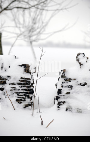 Eine Lücke in einer Steinmauer Cotswold in Schneeverhältnissen UK Stockfoto