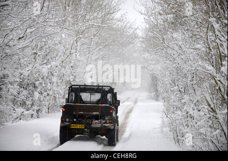 Ein Landrover-Jeep 4 x 4 auf eine Spur in den schneebedeckten Bedingungen in Gloucestershire UK Stockfoto