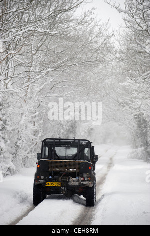 Ein Landrover-Jeep 4 x 4 auf eine Spur in den schneebedeckten Bedingungen in Gloucestershire UK Stockfoto