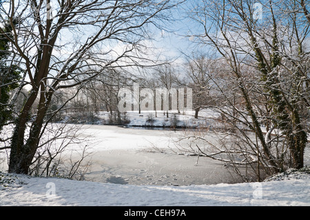 Zugefrorenen Teich mit Schnee bedeckten Bäume und Wald. Hampstead Heath, London. Stockfoto