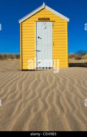 Die alten traditionellen Strandhütten unter die Sanddünen in Southwold in Suffolk Stockfoto