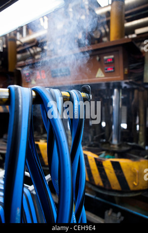 Blau, unaufgeblasen Fahrradreifen hängen in der Hutchinson-Reifenfabrik Stockfoto