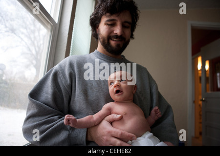 Vater sein glücklich neugeborenes Mädchen, Blick aus Fenster zu Hause halten. Stockfoto