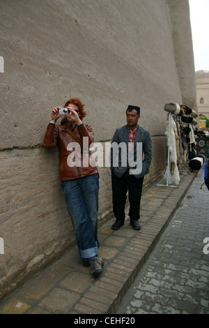Tourist, beobachtet durch traditionelle lokale Mann in Chiwa, Usbekistan Stockfoto
