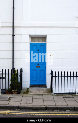 Blaue Tür auf Stadthaus in der Zeile der Reihenhäuser in North Laine, Brighton, England Stockfoto