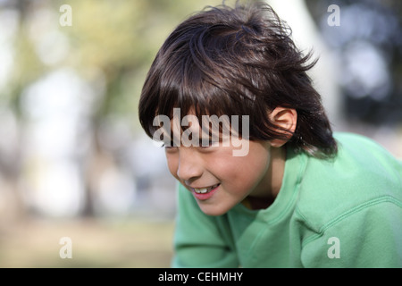 Glücklicher Junge schaut etwas aufmerksam. Geringe Schärfentiefe mit Bokeh Hintergrund und Kopie Raum nach links. Stockfoto