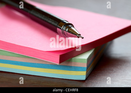 Druckbleistift mit einem Haufen von Aufklebern auf dem Schreibtisch Stockfoto