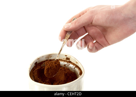 Die Hand des Mannes mit Löffel entnimmt Kaffee Kaffeemühle auf weißem Hintergrund Stockfoto