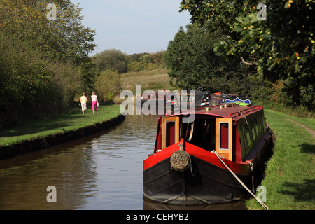 Hausboote auf dem Llangollen Kanal in der Nähe von Whitchurch, Shropshire UK, mit Menschen zu Fuß entfernt von der Kamera auf dem Treidelpfad Stockfoto