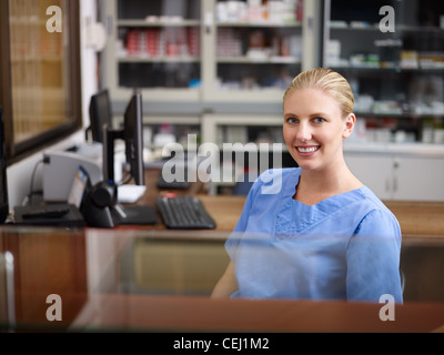 Junge Frau bei der Arbeit als Empfangsdame und Krankenschwester im Krankenhaus, Blick in die Kamera Stockfoto