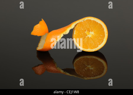 Eine halbe Orange geschält isoliert auf einer grauen reflektierenden Oberfläche Stockfoto