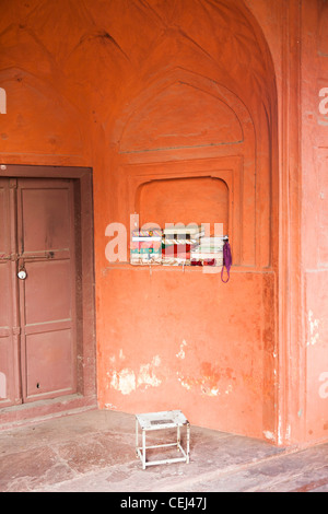 Schals und Tücher wickeln Kopien des Korans in Terrakotta farbigen Alkoven, Jama Masjid Moschee, Alt-Delhi, Indien Stockfoto