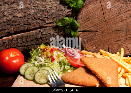 Tschechische Gebackener Käse mit Pommes Frites und Salat (Kopfsalat, Gurke, Zwiebeln und Tomaten) Stockfoto