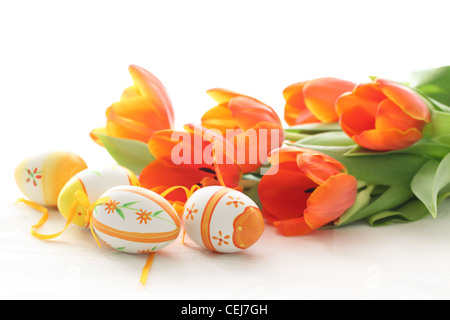 Ostereier mit orange Tulpen isoliert auf weißem Hintergrund Stockfoto