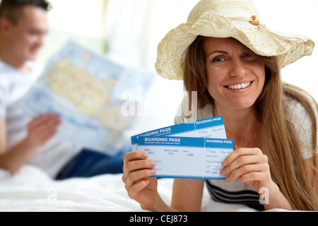 Glückliche Frau mit Hut zeigen Flugtickets Stockfoto