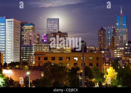 Full Moon rising hinter der Skyline von Denver Colorado in der Nacht. Stockfoto