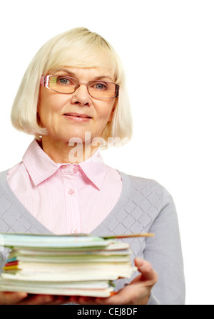 Schöne Reife Dame hält einen Stapel Notizbücher Bücher und lächelt in die Kamera Stockfoto