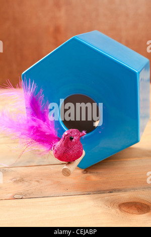 Vogel im blauen Nest Haus polygonale Form über Holz Stockfoto