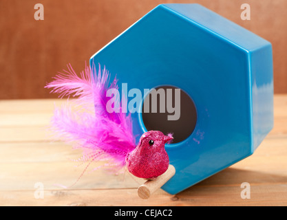 Vogel im blauen Nest Haus polygonale Form über Holz Stockfoto