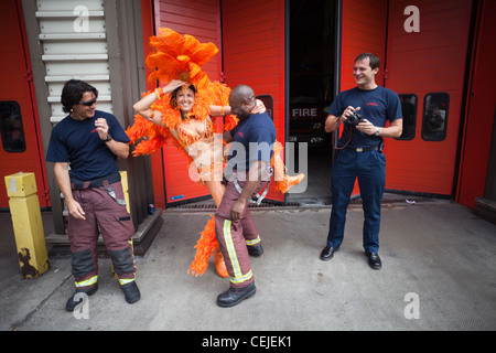 England, London, Notting Hill Carnival, Feuerwehrmann und weibliche Teilnehmer tanzen Stockfoto