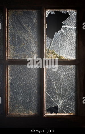Ein altes Fenster mit zwei seiner Scheiben gebrochen Stockfoto