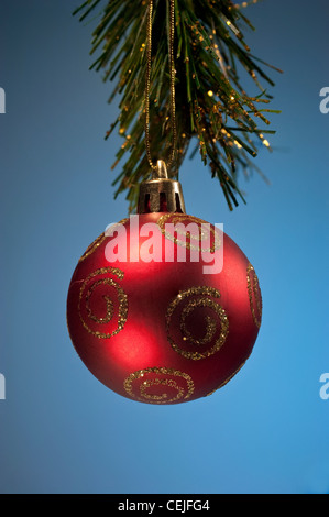 Eine rote Kugel Weihnachtsdekoration auf blauem Grund Stockfoto