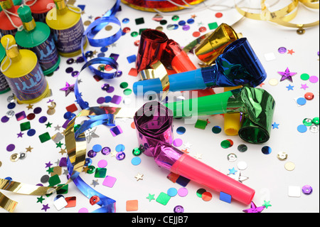 Ein Stillleben Bild der bunte Konfetti, Horn Gebläse, Luftschlangen und Party Poppers auf weißem Hintergrund Stockfoto
